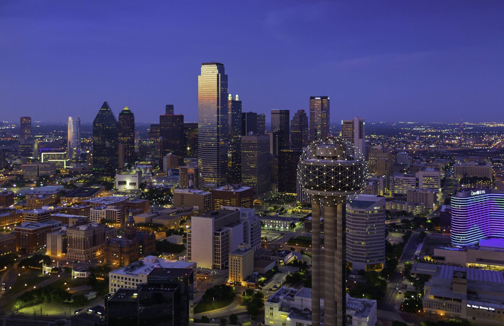 Illuminated Dallas Texas skyline at dusk.