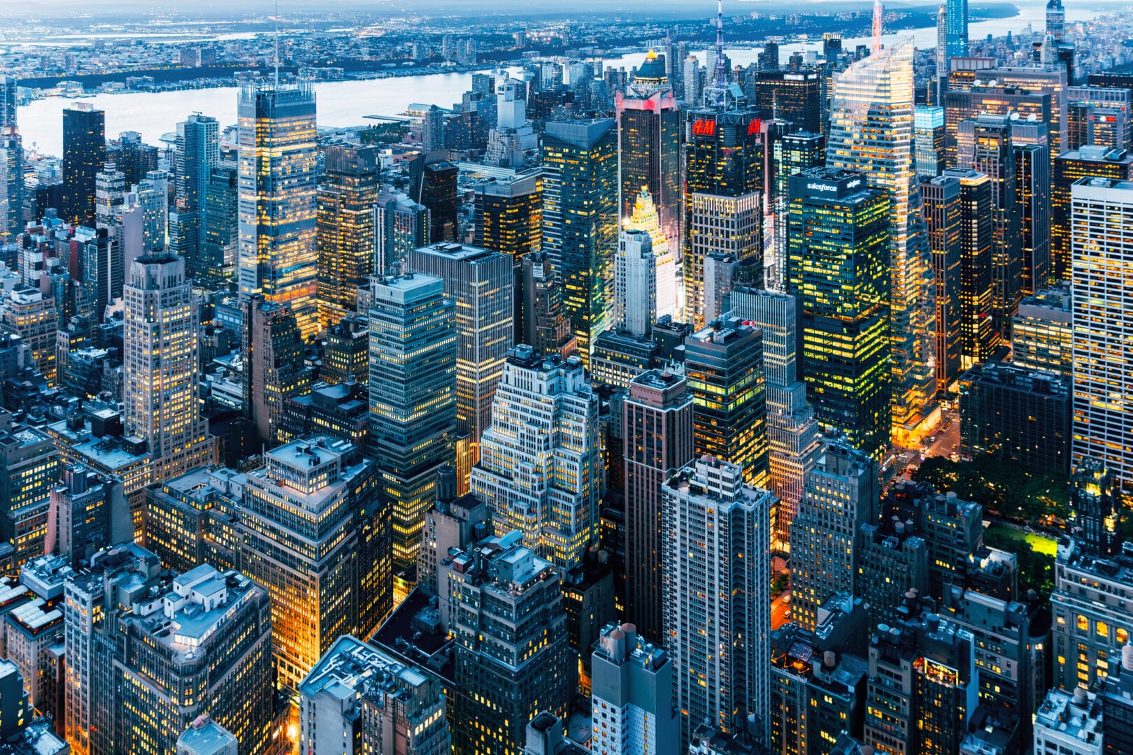 New York illuminated cityscape at dusk, aerial view.
